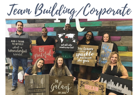 2-corporate a group of people posing for a photo in front of a sign