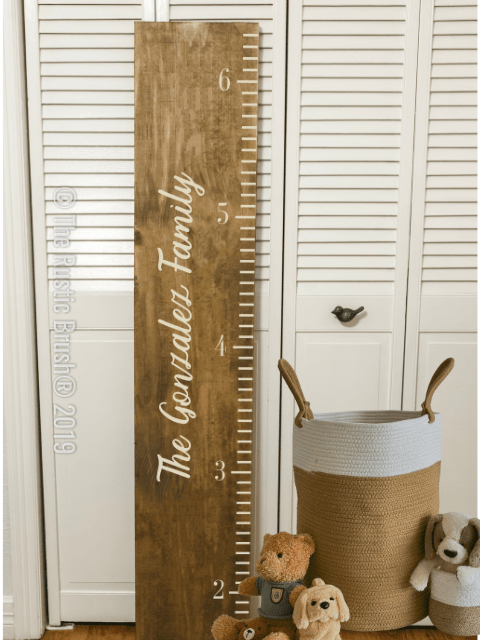 Wooden growth chart with 'The Gonzalez Family' next to stuffed animals in a basket.