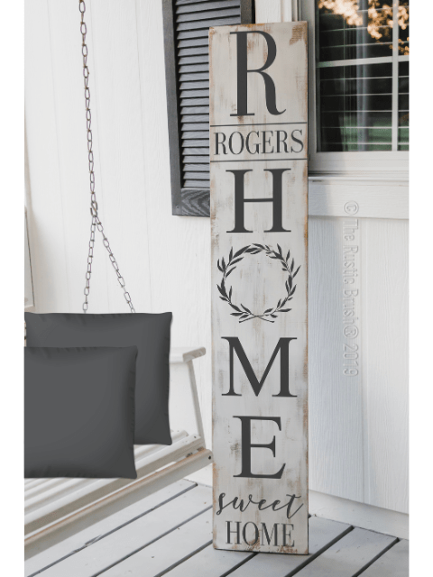 Wooden sign with 'R Home Sweet Home' text, next to a porch swing.