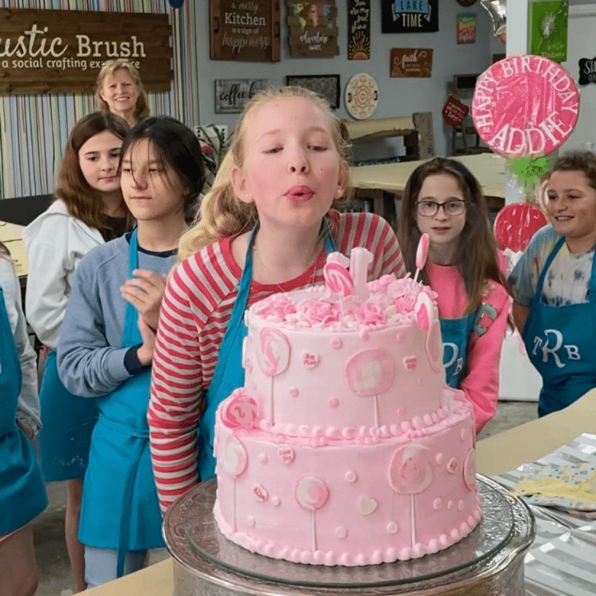 Liana Jackson et al. posing for a photo in front of a birthday cake