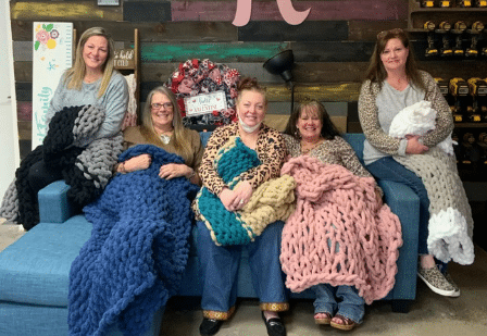 a group of people standing next to a teddy bear