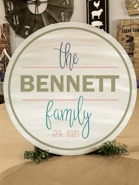 Round wooden sign with 'The Bennett Family Est. 2020' in elegant script.