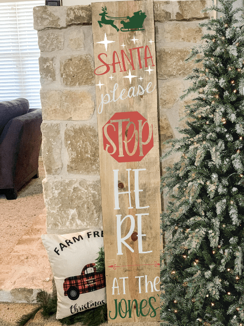 Christmas sign by a tree reads 'Santa please stop here at the Jones'.