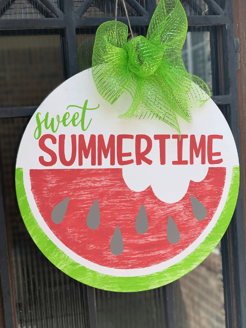 Door sign with 'sweet summertime' and watermelon design, topped with a green ribbon.