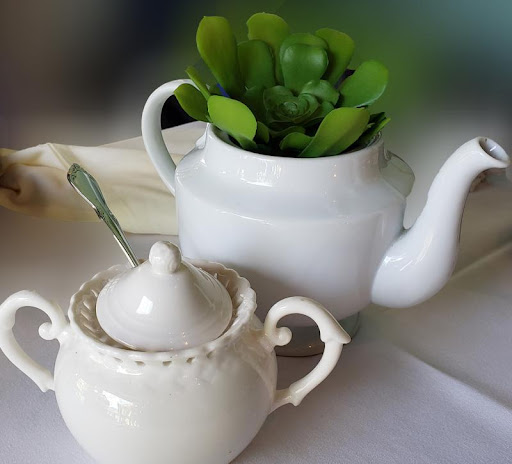 a cup of coffee and a vase of flowers on a table