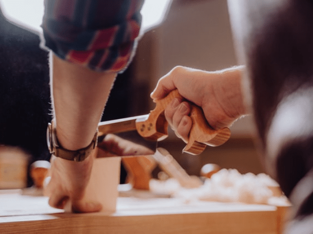 a person cutting a piece of cake on a table