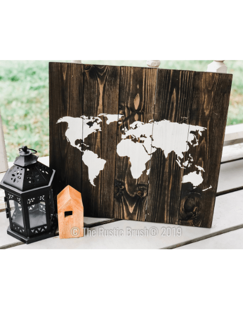 Wood plank decoration with world map next to black lantern and small house on a porch.