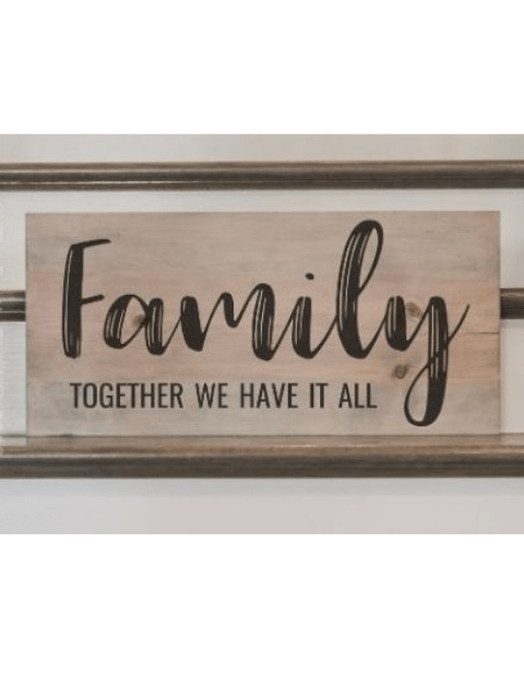 Wooden sign with 'Family: Together We Have It All' in black script.