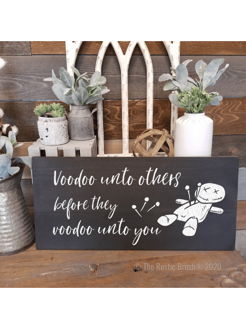 Decorative sign with a voodoo doll and the text, 'Voodoo unto others before they voodoo unto you.'
