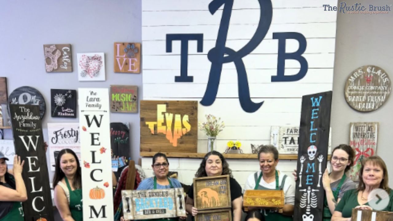 Group of people in aprons holding handmade decorative signs in front of a wall with 'TRB' logo.