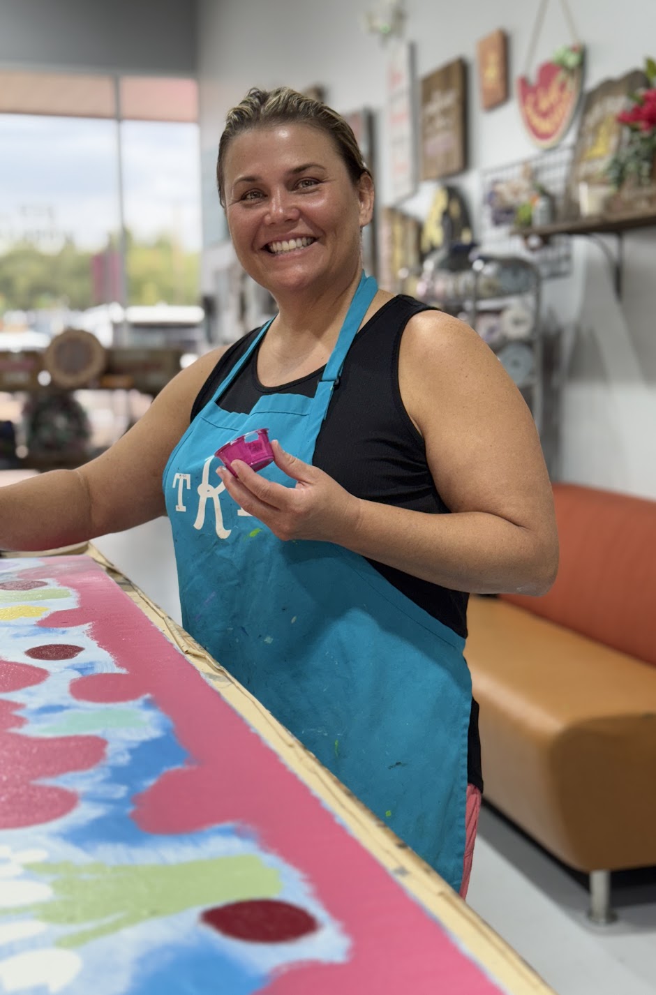Woman posing with a cup of paint at The Rustic Brush