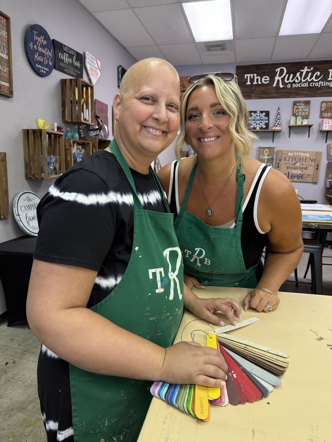 t: Two women at a crafting table with color samples at The Rustic Brush workshop.