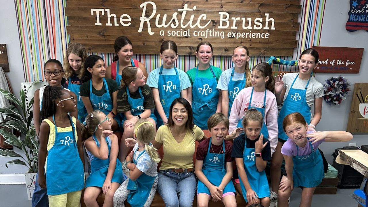Group of kids and instructor smiling together at a children’s art camp