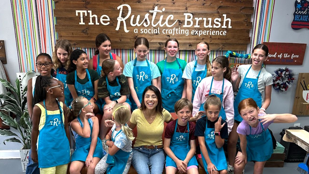Group of kids and instructor posing together at The Rustic Brush art camp