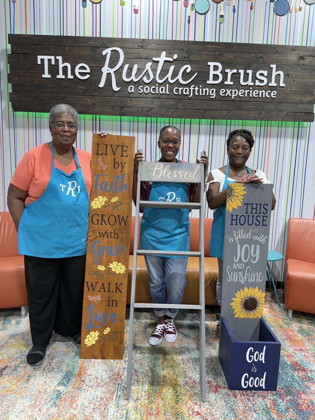 Participants showcasing completed DIY wood sign projects.