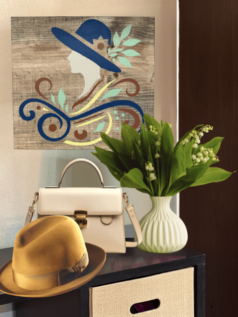 Decorative hat art, white purse, and yellow hat on a table with lilies in a vase