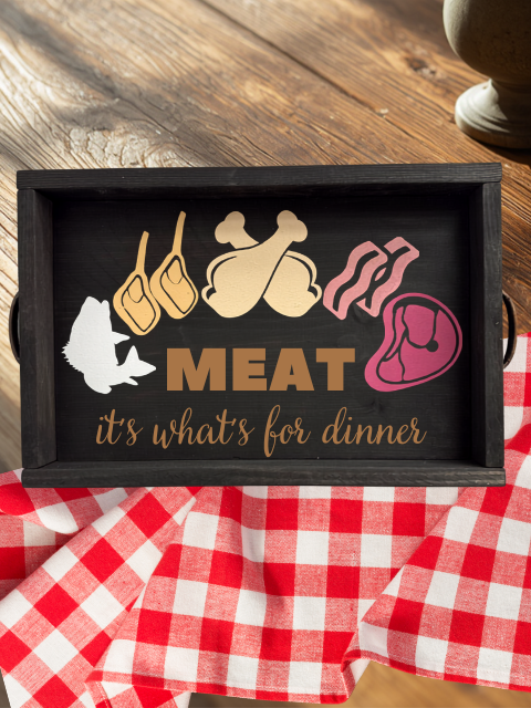 Tray with meat icons and text 'Meat, it's what's for dinner' on checkered cloth.
