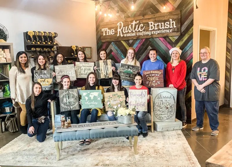 A group of youth proudly displaying their completed painted wood signs during a creative DIY art class at The Rustic Brush. (1)