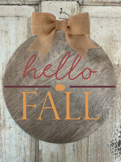 Round "hello FALL" wooden door hanger sign with a burlap bow.