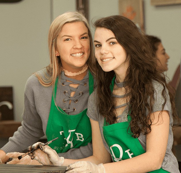 Two girls posing inside The Rustic Brush craft studio before a fun painting and woodworking workshop. (1)