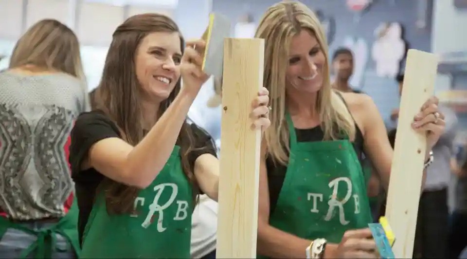 Two women sanding wooden planks at a craft workshop at The Rustic Brush.